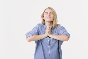 Portrait of young cheerful blonde woman wearing blue shirt against white background