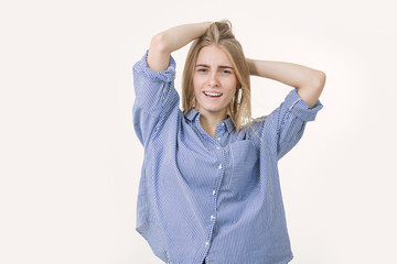 Portrait of young cheerful blonde woman wearing blue shirt against white background