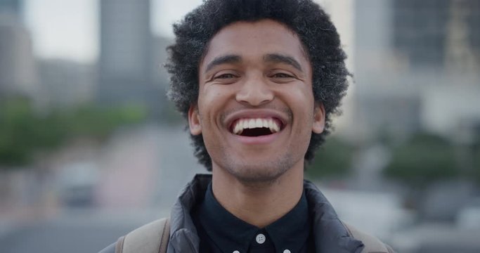 portrait independent young mixed race businessman laughing enjoying professional urban lifestyle in city cheerful male afro hairstyle slow motion