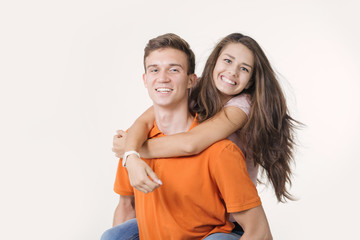 Happy lovely couple hugging and smiling looking at camera on white background