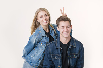 Woman pranking her boyfriend with bunny ears. Studio shot over white background