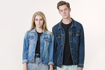 Unhappy young couple standing together over white background. Friendship, love and relationships...