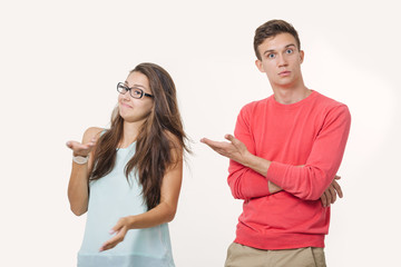 Studio shot of disgruntled couple wearing casual clothes standing back to back frowning their...