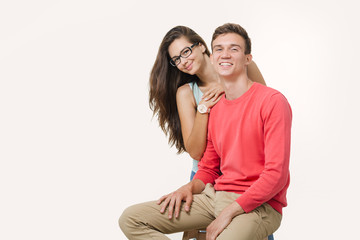 Happy lovely couple hugging and smiling looking at camera on white background