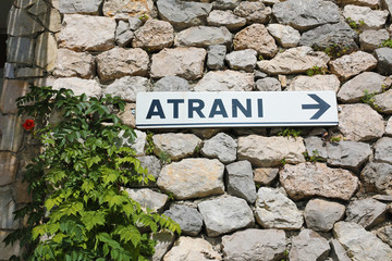 Atrani direction road sign on wall stones in Amalfi Coast, Italy
