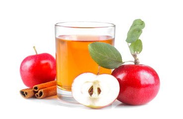 beautiful mature fresh red apple with green leaves and apple juice next to cinnamon on white isolated background