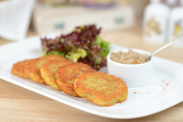 Traditional Belarus potato pancakes (draniki) with sauce cream in a plate at a cafe