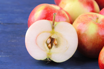 Fresh ripe apple in a close-up cut on a blue wooden background