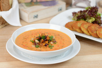 pumpkin soup with beans and croutons on a white plate