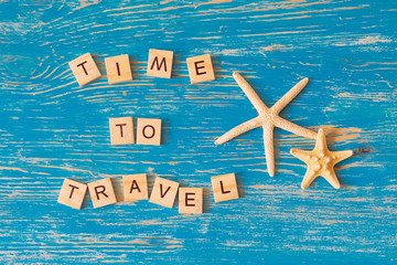 Fototapeta na wymiar time to travel concept. text on blue wooden background. overhead view