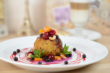 baked apple with berries on a white plate