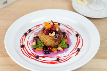 baked apple with berries on a white plate