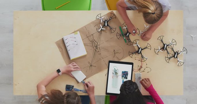 top view young group of multi ethnic student girls time lapse building drones together smart intelligent children design uav technology camera close up