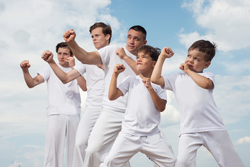 Several capoeira athletes are standing in the fighting stance.