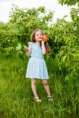 little girl in summer in green with red apple