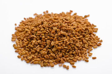 fragrant grains of fenugreek on a white background