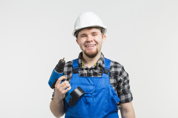 Close-up of handsome male builder with screwdriver wearing white helmet.