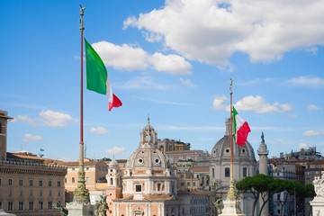 Italian flags with a glimpse of the roofs of Rome