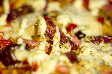 homemade pizza with peppers, plums, ham, sausage, cheese and spices, closeup