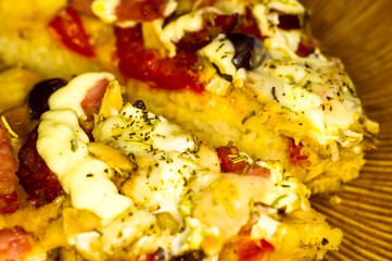 homemade pizza with peppers, plums, ham, sausage, cheese and spices, closeup