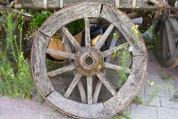 Fototapeta na wymiar old wheel is leaning against the old horse car