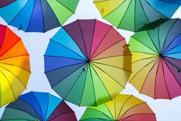 Multi-colored umbrellas background. Colorful umbrellas floating above the street. Street decoration.