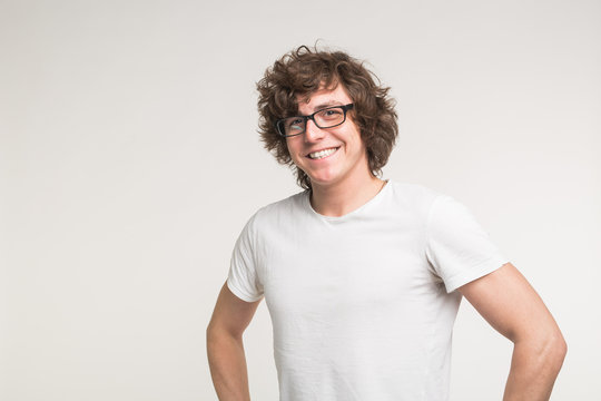 Portrait of positive stylish student man in glasses and casual outfit on white background