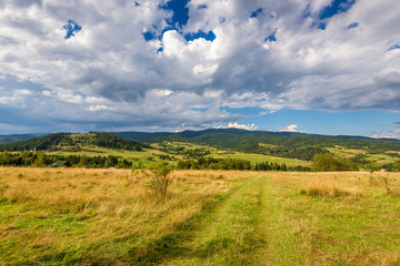 Rural scenery. Fields, mountains and clouds on the sky. Pieniny National Park. Malopolska, Poland..
