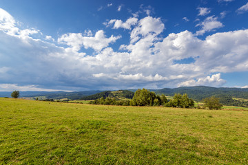 Rural scenery. Fields, mountains and clouds on the sky. Pieniny National Park. Malopolska, Poland.