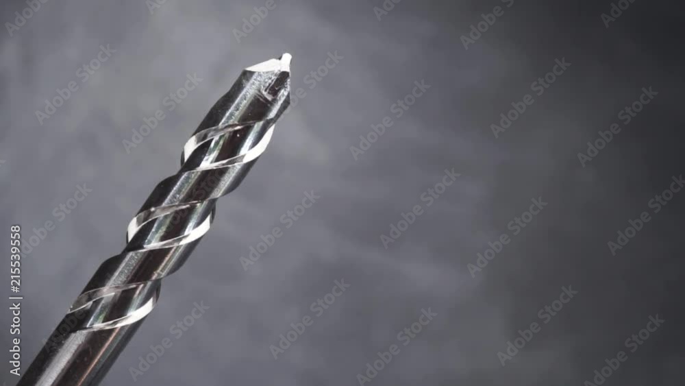 Poster Silver drill bit rotation on a dark background. Macro view.