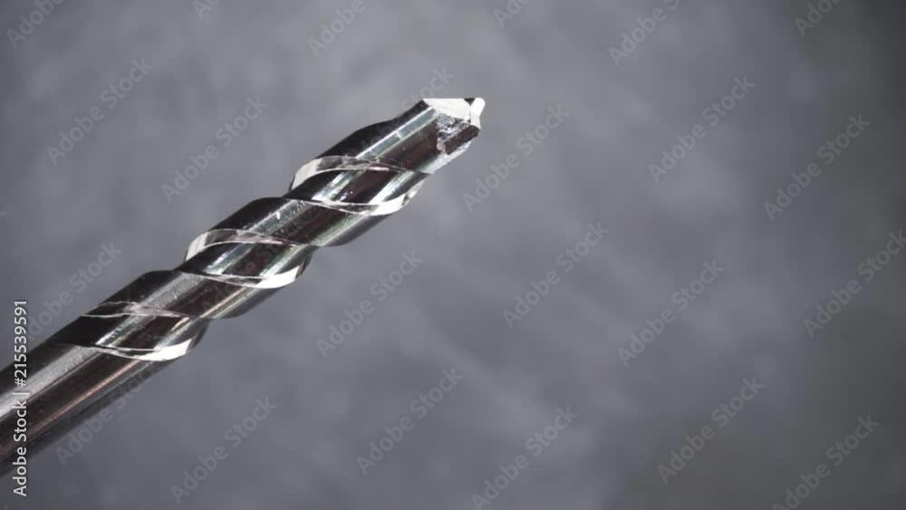 Poster Silver drill bit rotation on a dark background. Macro view.