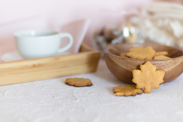 Fototapeta na wymiar Cozy autumn breakfast with homemade honey cookies shaped as maple leaves and cup of tea