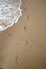 Fußspuren im Sand an Wasserkante