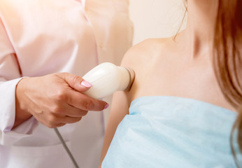 Ultrasound treatment in physical therapy. Doctor using an ultrasound machine to treat the joints and muscles of a patient