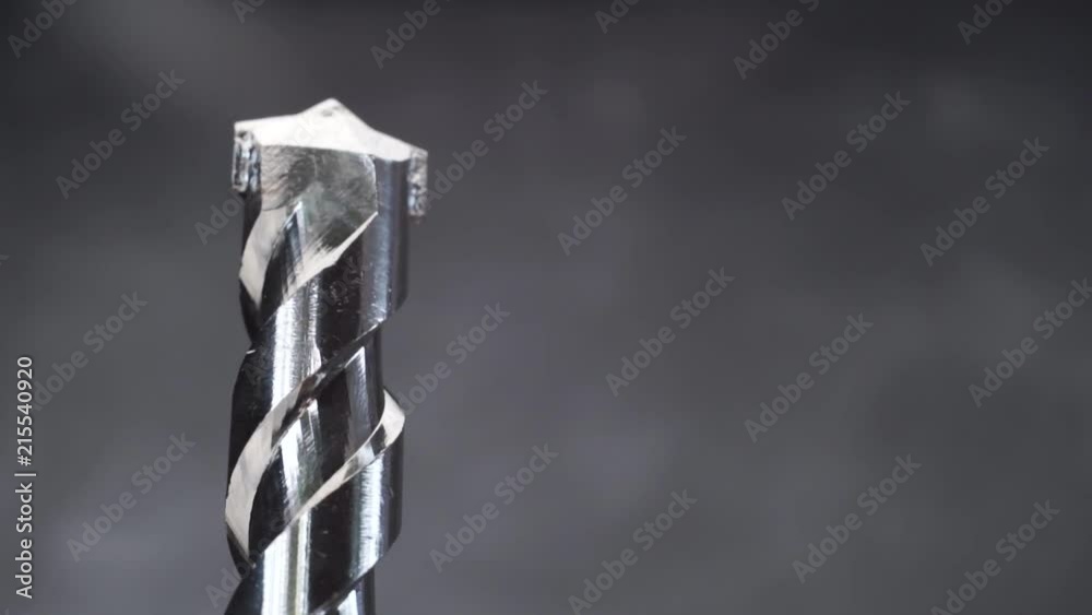 Poster Silver drill bit rotation on a dark background. Macro view.