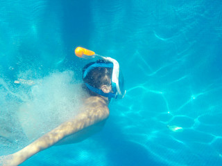 El niño esta buceando en la piscina con easybreath snorkeling mask
