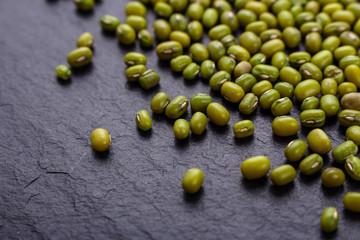 fresh Mung beans on a dark stone background