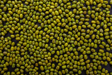 fresh Mung beans on a dark stone background