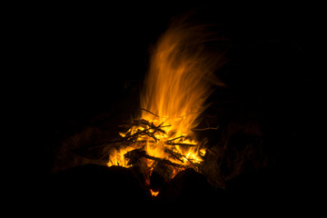 flame of a fire, in which natural brushwood burns, on a black background