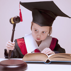 One law for all concept. Portrait of serious child girl judge (lawyer) makes a decision. Humorous...