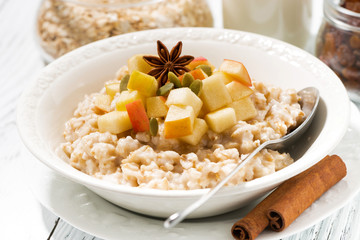 plate of oatmeal with apples and spices, closeup