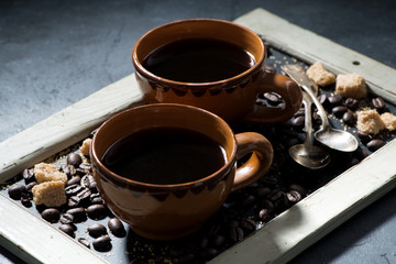 two cups of black coffee and sugar on the blackboard, horizontal