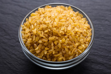 raw bulgur on a dark stone background