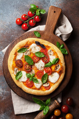 Italian pizza with tomatoes, mozzarella and basil