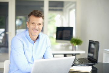Successful businessman working on laptop at the office - obrazy, fototapety, plakaty