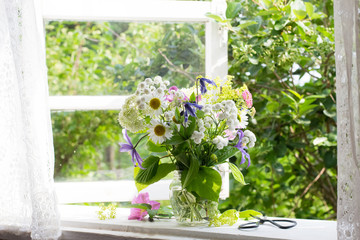 Bouquet of garden flowers on window