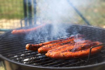 Close-up of a bunch of merguez sausages roasting on a barbecue grill. Selective focus.