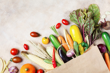 Autumn vegetables background. Organic food in paper bag top view.