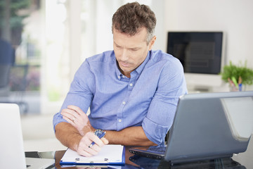 Businessman working on laptop and doing some paperwork