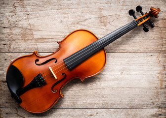 Fototapeta na wymiar Brown violin on wooden background. Art and music background. Top view.
